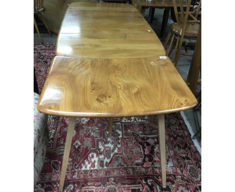 An Ercol, light elm drop leaf dining table and conforming tripod leg extension.Table approx 70x 1.33m