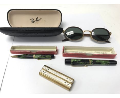 A pair of Ray-Ban sunglasses with original case. A Cartier lighter and pair of vintage boxed pens.