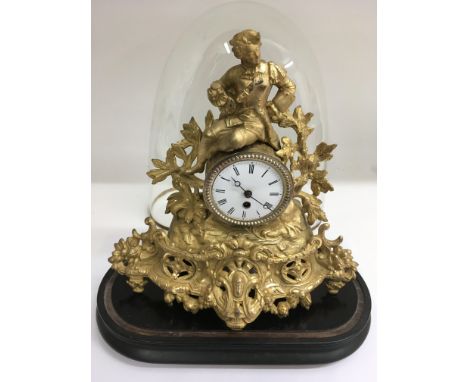 An ormolu spelter mantle clock under glass dome.Approx 38cm