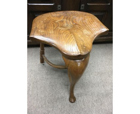 An elm saddle shape stool