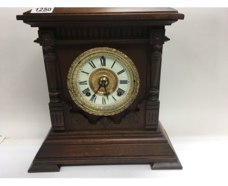 A walnut cased ansonia mantle clock the circular dial with Roman numerals and a slate mantle clock