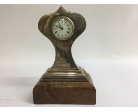 A silver mantel clock the enamel dial with Roman numerals on a walnut base 23 cm