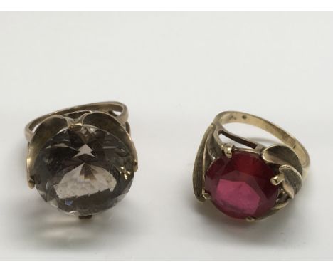 Two gold rings, one set with a central smoked quartz, the other with a red stone.Approx size M
