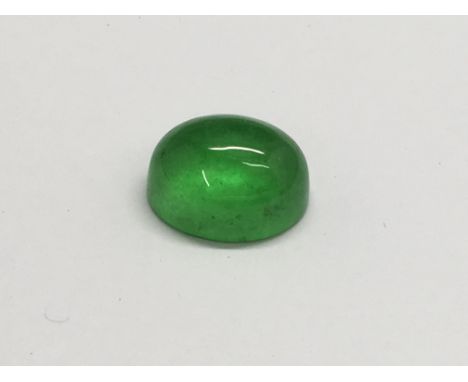 A polished spinach jade cabouchon stone.Approx 1.5cm long