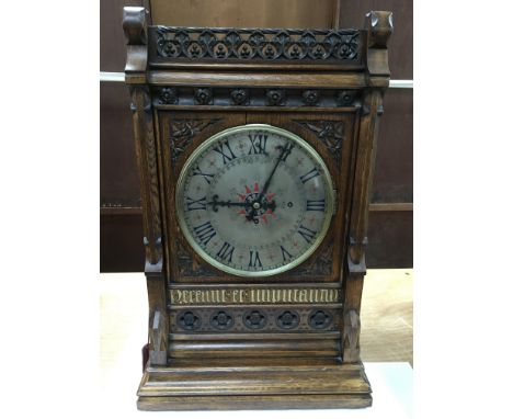 A fine quality Victorian Gothic revival bracket clock, the oak case carved with typical floral motifs and painted with Latin 