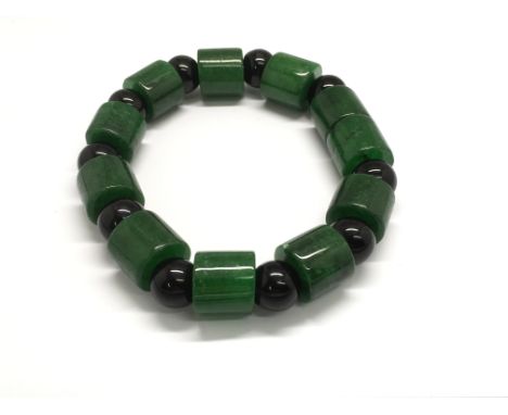 A polished spinach jade and black stone bracelet