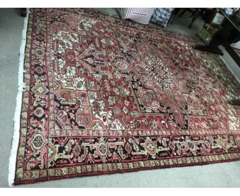 A quality 20th century hand knitted Iranian carpet with red geometric pattern. Size as shown on label