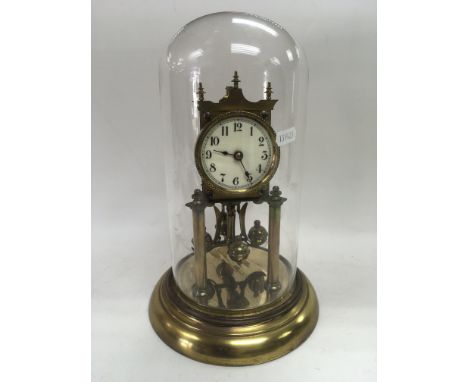 A brass clock under a glass dome, total height approx 30.5cm.