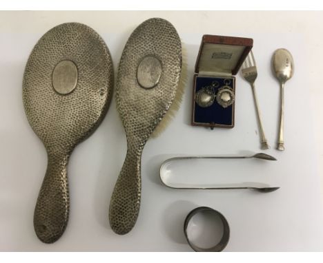 A collection of silver comprising silver backed mirror and brush tongs spoon and fork , napkin ring and silver medallion