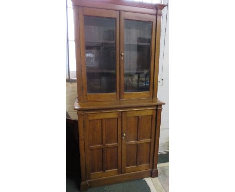 An early 20th century oak bookcase, overall with an Arts and Crafts influence and breakfront detail, the top with two plain g