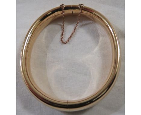 **Payment in person or by bank transfer only**A yellow metal plain hollow bangle, stamped 15, safety chain, 9.7g, with a red 