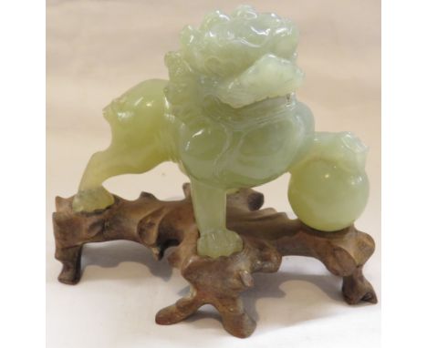 Chinese jade colour carved stone figure of Fo Dog (part tail missing), height including wooden stand 9cm