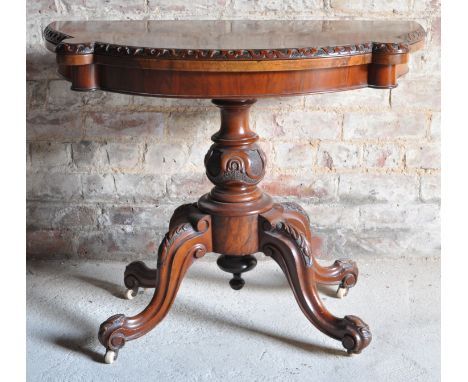 A Victorian figured walnut semi circular Card Table with carved edge and fold-over baize lined top on a baluster turned colum