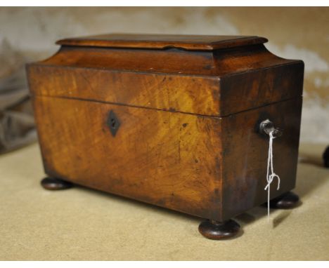A 19th century mahogany sarcophagus shape Tea Caddy, the interior fitted with two containers and bowl recess, on compressed b