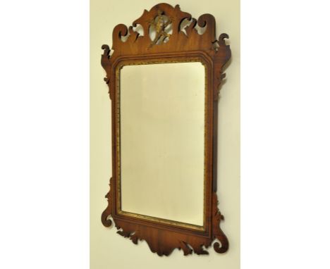 A Chippendale design upright Wall Mirror with gilt eagle finial and gilt slip in a fret carved mahogany frame, 29" (74cms) x 