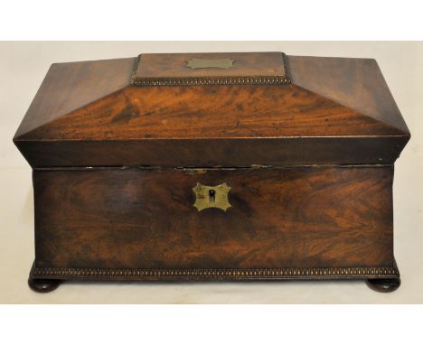 A mid 19th Century figured mahogany sarcophagus shape Tea Caddy, the interior with glass bowl and two covered containers and 