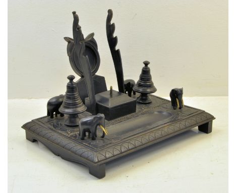 An Indian ebonised Desk Stand with carved and incised decoration, with covered stamp box, watch stand, inkwells, pen tray, et