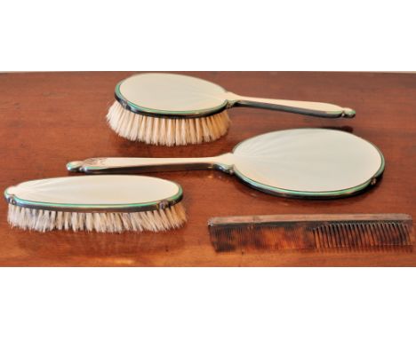 A silver and cream enamel three piece Dressing Table Set, Birmingham 1948, and a silver mounted Comb. 