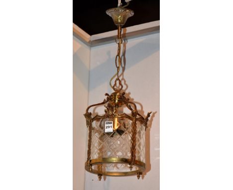 An Arts & Crafts gilt metal ceiling light, the frame decorated with stylized and fern shaped supports, with circular glass in