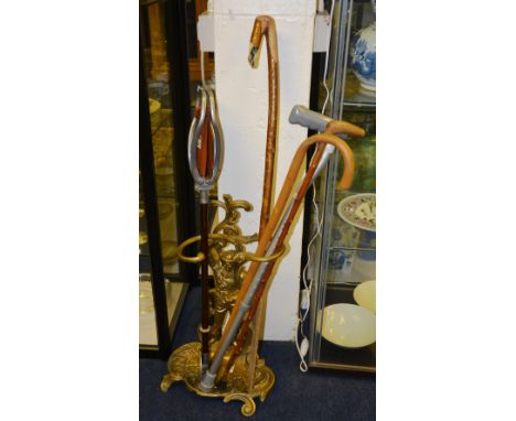 A gilt metal stick stand, in the Victorian style, modelled as a man above a scroll shell shaped base, 58cm high, together wit