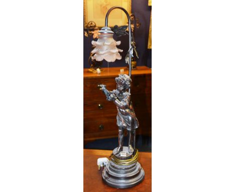 A figural table lamp in the Art Nouveau style, with pink glass shade, decorated with child playing a flute, 70cm high CONDITI