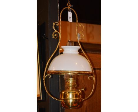 A hanging oil lamp, with ornate decoration, glass shade and funnel, 70cm high