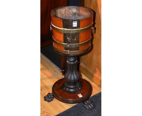 A converted mahogany jardiniere table, with circular top, raised on turned column, platform base with animal paw feet, 43cm h