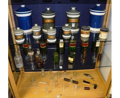 A large quantity of late 19th/early 20th century apothecary jars and bottles, both in ceramic and glass, the jars of graduate