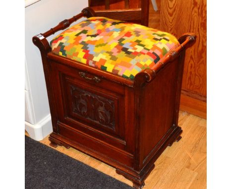 A mahogany piano stool, with upholstered cushion above pull out flap with magazine compartment to the opposite, 55cm high x 5