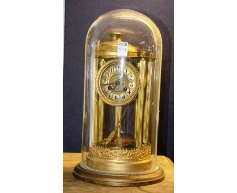 A Continental anniversary clock, the circular gilt dial with Arabic numerals above Greek column style pillars, with glass dom