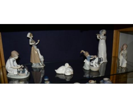 Five Lladro figures, including a girl washing dog and girl playing with puppies, largest 28cm high, together with a Nao duck 