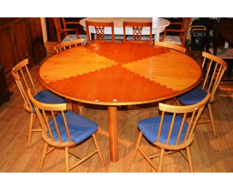 A large pine circular kitchen table, 76cm high x 130cm wide, with six Ercol style spindle back chairs (7)