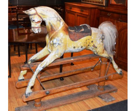 A vintage child's rocking horse, raised on swing wood frame, 125cm high x 145cm long CONDITION REPORT: Lot 523 - Mane lacking