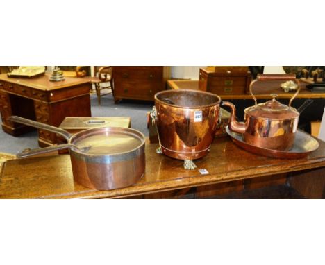 A vintage copper planter, with brass animal paw feet, 20cm high, together with a copper tea kettle and three copper pans (5)