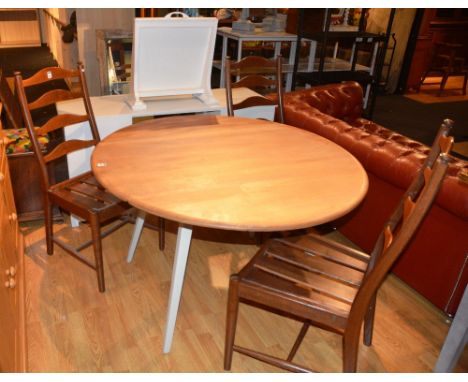 A blonde Ercol kitchen table, with drop leaves, and three matching oak ladder back chairs, 71cm high x 114cm long x 125cm wid