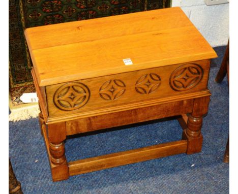 An oak stool, with hinged lid above carved frieze raised on turned supports and plain stretchers, 44cm high x 56cm wide x 32c