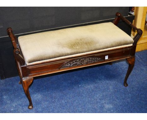 A mahogany duet piano stool, with green velour upholstered hinged seat, above carved foliate frieze, raised on cabriole suppo