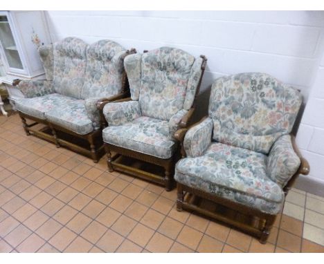 AN ERCOL THREE PIECE LOUNGE SUITE, with removable upholstered cushions, comprising of a two seater settee and two armchairs