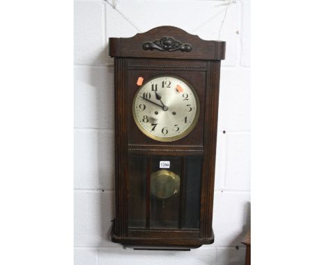 AN OAK CASED WALL CLOCK (key and pendulum)