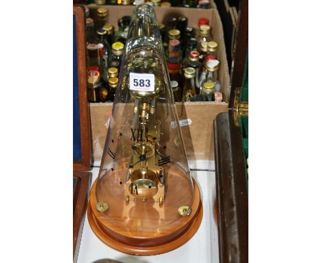A FRANZ HERMLE BRASS SKELETON CLOCK, glass conical dome bearing Roman numerals to the quarters, on circular wooden base, heig