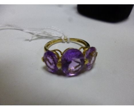 A 9CT GOLD AMETHYST RING, with three oval shape amethyst to the plain tapered band, stamped 9k, ring size P