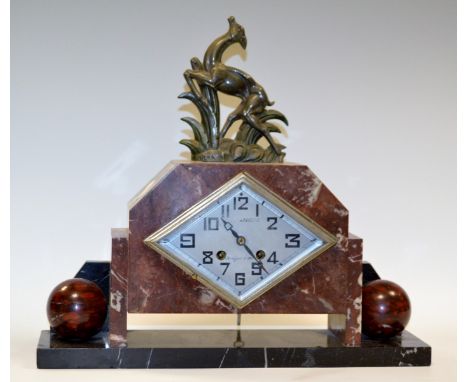 An Art Deco rouge marble clock, the navette shaped silvered dial with Arabic numerals, twin winding holes, the marble case su