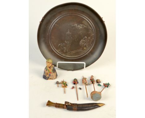 An oriental metal dish decorated with figures holding a banner and flowering tree, diameter 24cm, together with a miniature k