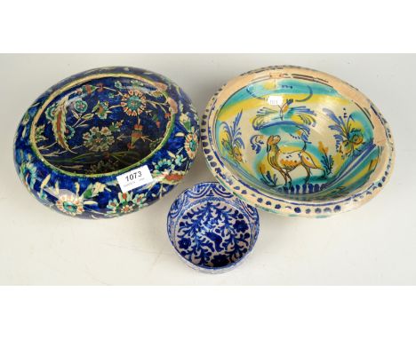 A middle eastern blue glaze bowl decorated with flowering tendrils, a Spanish Moorish blue and white dish and a similar hunti
