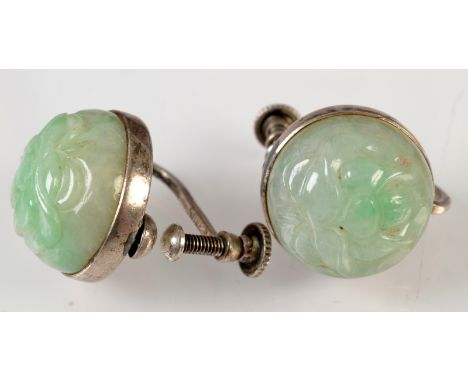 A pair of Chinese pale green carved jade silver mounted screw on earrings. 