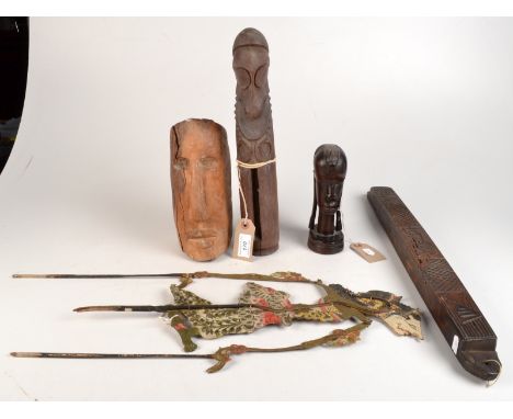 A maori tiki style carving, three other native carvings and a shadow puppet. 