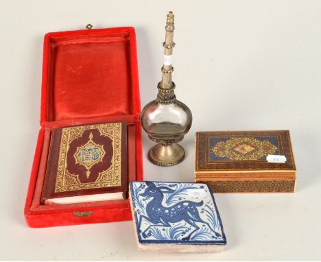 An Islamic white metal and glass scent bottle, height 22cm, a cased old leather bound Quran, together with a bank note, a Per
