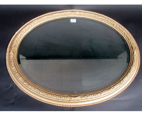 An oval gilt framed mirror.