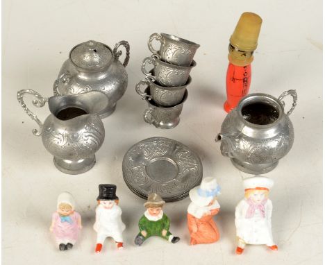 A celluloid necessaire in the form of a child, its coral coloured body a needle case, together with a pewter dolls tea servic
