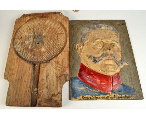 A cast iron portrait of General Field Marshal von Hindenburg and a continental wooden dairy mould/press.